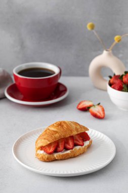 Taze ricotta ve taze çilekli kruvasan. Fransız kahvaltısı konsepti. Sade kahveyle kruvasan..