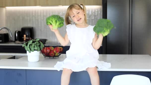 Seorang Gadis Manis Bersenang Senang Dengan Brokoli Duduk Meja Dapur — Stok Video