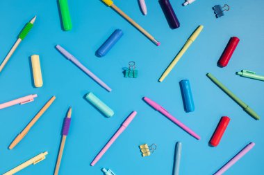 Mavi arka planda parlak kırtasiye malzemeleri ve okul malzemeleri var. Okula dönelim. Düz yatıyordu