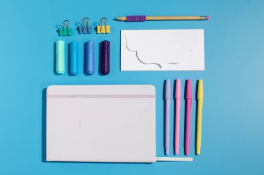 Mavi arka planda parlak kırtasiye malzemeleri ve okul malzemeleri var. Okula dönelim. Düz yatıyordu