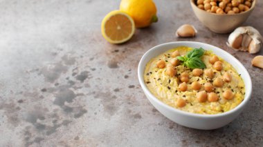 Rangpur 'daki bir masaya nohut ve fesleğenli bir kase humus konur. Bu yemek malzemelerle yapılır. Boşluğu kopyala