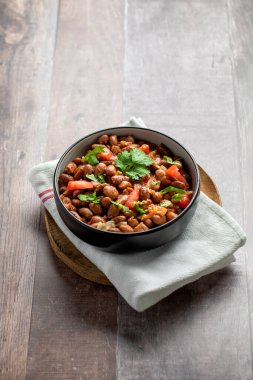  Vejetaryen yemeği, haşlanmış pembe fasulye ve domates. Tahta masada servis edilen lezzetli bir fasulye yemeği..