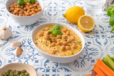 Masa takımında taze havuç, kereviz, kabak çekirdeği ve sarımsak ile servis edilen rahatlatıcı bir tabak humus. Besleyici ve lezzetli bir yemek. Atıştırmak ya da paylaşmak için mükemmel.