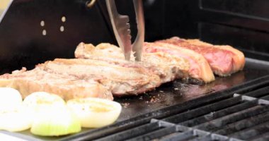 Taze bir biftek dışarıda ızgarada kızartılıyor. Barbekü konsepti.