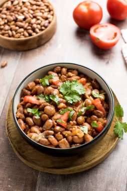 Vejetaryen yemeği, haşlanmış pembe fasulye ve domates. Tahta masada servis edilen lezzetli bir fasulye yemeği..