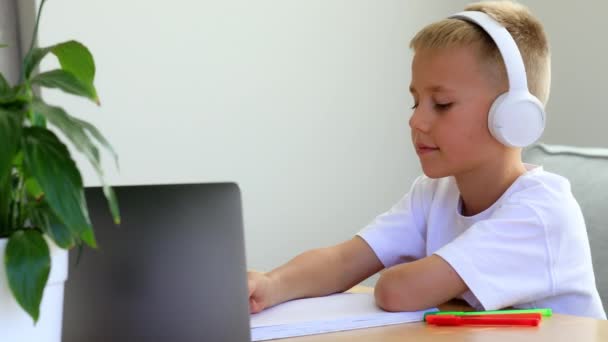 Маленький Мальчик Наушниками Слушает Учителя Время Онлайн Урока Дома Ученик — стоковое видео