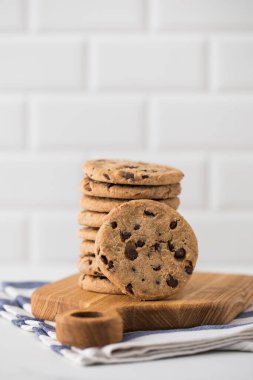 Tahtaya çikolata parçacıklı kurabiyeler yığılmış. Ev yapımı kurabiyeler..