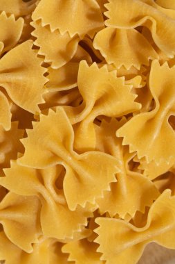 Pişmemiş papyonlu makarna, farfalle, dokusunu ve karmaşık detaylarını gösteren makro çekim.