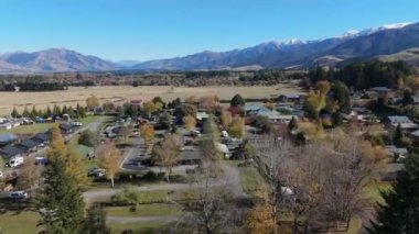 Vadideki küçük bir kasaba ve orman büyük dağların manzarasına karşı. Köy, sonbahar günü eski kar kaplı bayırın dibine yerleştirildi. Panoramik doğa