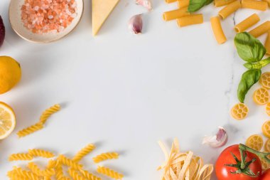 Beyaz mermer masa manzaralı el yapımı makarna ve yemek malzemeleri çerçevesi. Vegan beslenme istihkakı için sağlıklı gıda ürünleri. Boşluğu kopyala