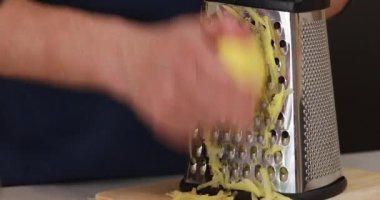 Videoda, bir adam patatesleri rendeleyip lezzetli patatesli krep yapmak için adım adım talimat veriyor.