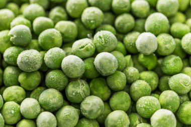 Donmuş taze bezelyelerin yakın çekimi. Üzerinde don olan sağlıklı ve taze sebzeler, besleyici yemek için mükemmel.