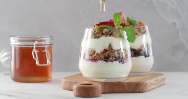 Naneli ve böğürtlenli iki yoğurt, ahşap bir tahtaya konmuş..