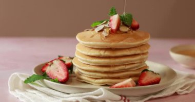 Üzerine taze çilek, nane yaprağı ve şerbetli badem serpiştirilmiş lezzetli pofuduk krepler..