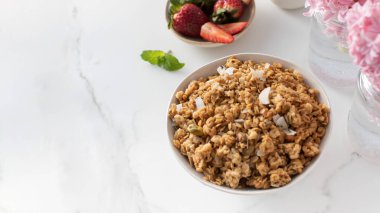 Çilekli bir kasede dilimlenmiş bademle ev yapımı gevrek. Sağlıklı yemek için ideal. Boşluğu kopyala