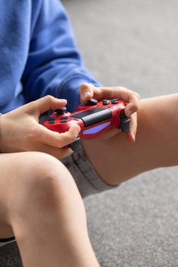 Oyun kumandasını tutan bir çocuğun yakın çekimi. Oyun konsepti, oyun konsolları.