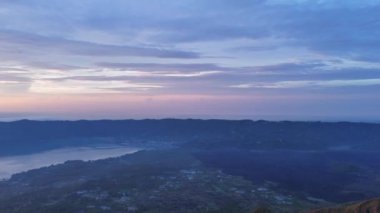 Nefes kesen bir manzara alacakaranlık gökyüzü zarif bir şekilde sakin ve sakin dağ manzaraları üzerine uzanıyor. Sabahın erken saatlerinde Bali 'deki Batur Volkanı aydınlanır.