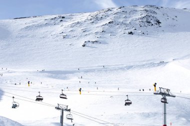 Karlı dağ yamacının üzerindeki teleferik kablo yolunda. Turistlerin Yeni Zelanda 'daki tatil beldesinde kayak yapmak için tepe noktalarına nakledilmesi. Hutt Dağı 'nı ziyaret ediyorum.