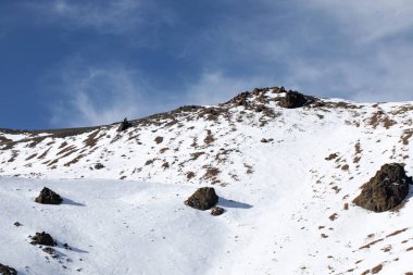 Kar tepeli kaya dağları açık bulutlu mavi gökyüzüne karşı yükseliyor. Yeni Zelanda kayak merkezindeki Hutt Dağı tepesi inanılmaz. Vahşi dağlık güzellik
