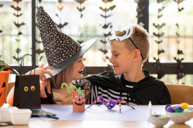 Şirin erkek ve kız kardeşler, Cadılar Bayramı 'nı kutlamak için karnaval kostümleriyle eğlenir ve el işi yaparlar. Mutlu Cadılar Bayramı. 