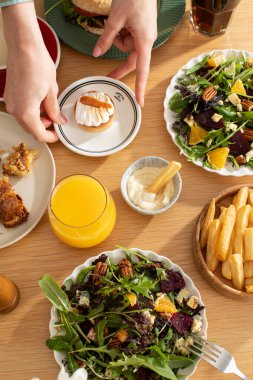 Kadın, Cafe Upview 'deki yemek masasına kremalı tart koyuyor. Bayan yakın planda vejetaryen yemeklerine sağlıklı tatlı ekliyor. Gurme yaşam tarzı