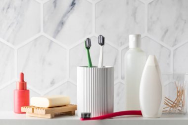 Banyo rafında kişisel hijyenik tuvalet malzemeleri koleksiyonu. Tezgahta diş fırçası, sabun ve kozmetik ürünleri var. Vücut yıkama ve bakım prosedürleri