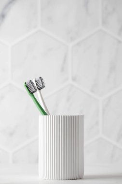 Seramik arka planda aile diş fırçaları. Tuvaletteki kişisel hijyen aksesuarları. Diş sağlığı malzemeleri evde.