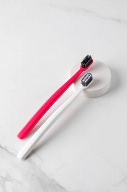 Diş fırçaları banyodaki raflarda düzgünce yerleştirilmiş. Diş fırçaları plakları ve yiyecek parçacıklarını etkili bir şekilde kaldırmaya yardımcı olur. Oral sağlığı korumak için araçlar