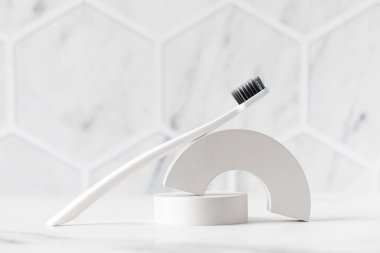 Uzun saplı beyaz diş fırçası ve hafif arka planda duran ultra yumuşak tüylü. Diş fırçası dişlerin temiz ve diş etlerinin sağlıklı kalmasına yardımcı olur. Diş bakımı aracı