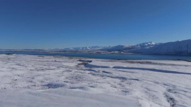 Tekapo Gölü soğuk kış günlerinde güzelliğe hayrandır. Turkuaz su ve göl kıyısının dağlara karşı beyaz karla kaplı büyüleyici manzarası.
