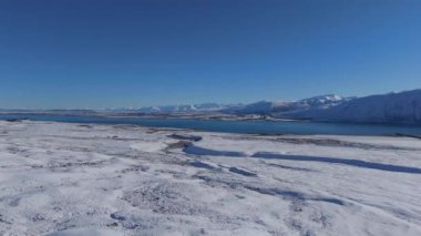 Tekapo Gölü soğuk kış günlerinde güzelliğe hayrandır. Turkuaz su ve göl kıyısının dağlara karşı beyaz karla kaplı büyüleyici manzarası.