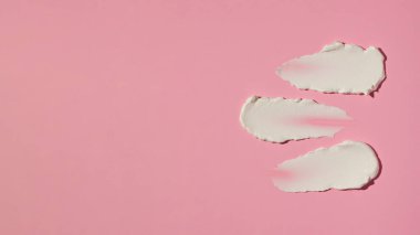 Kozmetik ürünleri ve doku örnekleri, pembe arka planda cilt bakımı için krem. Örnekler. Cilt bakımı. Uzayı kopyala Pankart