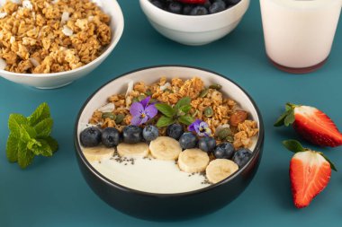 Doğal Yunan yoğurtları, granola ve taze böğürtlenlerden oluşan sağlıklı besleyici bir kahvaltı. Kahvaltı konsepti.