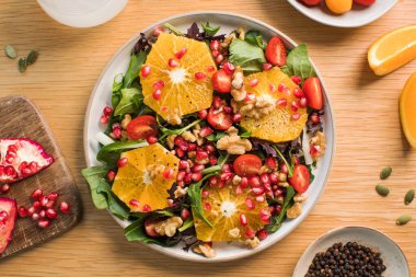Turunçgil meyveli vejetaryen salatası, marul yaprağı ve nar. Noel salatası. Sağlıklı beslenme.