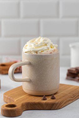 Ahşap tahtada yumuşak kremalı nefis kakao fincanı. Ev yapımı sıcak çikolata ve mandıra malzemesi. Kış için sıcak içecek.