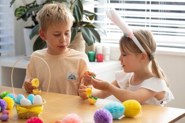 Çocuklar paskalya yumurtası avının ve renkli dekorasyonlu el sanatlarının tadını çıkarıyorlar. Çocukların yumurta avı kavramı. Mutlu Paskalyalar.