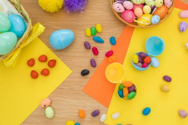 Paskalya yumurtaları içinde paskalya yumurtası şeklinde marmelatlar ve şekerlemelerle dolu parlak bir arka plan, Paskalya oyununa hazırlık. Yumurta avı konsepti. Mutlu Paskalyalar. Üst görünüm.