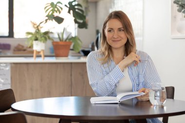 Kapalı mekan bitkileriyle deftere yazarken yansıyan kadın. Hedefler ve yalın
