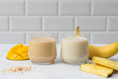 Hafif bir zemin üzerinde muz, ananas ve mango ile tropikal smoothie ferahlatıcı. Vejetaryen yemeği