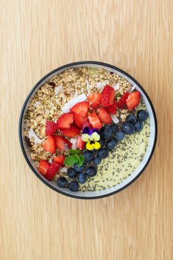 Tahta masada taze meyve ve chia çekirdekli sağlıklı kahvaltı avokado smoothie kasesi. Vejetaryen yemeği