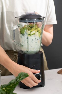 Blender 'da taze malzemelerle sağlıklı yeşil meyve püresi hazırlıyorum. Detoks kavramı