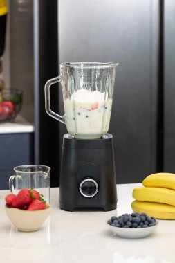 Modern mutfak ortamında sağlıklı bir yaşam tarzı için taze böğürtlen kokteyli hazırlıyorum. Detoks ve diyet kavramı