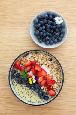 Tahta masada taze meyve ve chia çekirdekli sağlıklı kahvaltı avokado smoothie kasesi. Vejetaryen yemeği