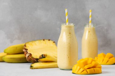 Yaz içeceği için mango, ananas ve muzlu tropikal smoothie. Detoks kavramı