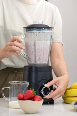 Modern mutfak ortamında sağlıklı bir yaşam tarzı için taze böğürtlen kokteyli hazırlıyorum. Detoks ve diyet kavramı