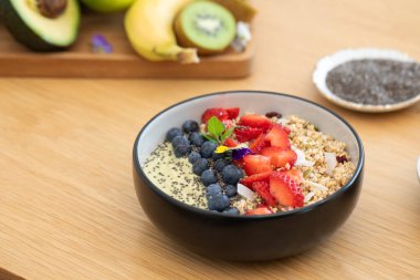 Tahta masada taze meyve ve chia çekirdekli sağlıklı kahvaltı avokado smoothie kasesi. Vejetaryen yemeği