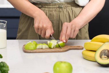 Taze meyveli sağlıklı yemekler, kesme tahtasındaki yeşil elmalar. Meyve kavramı