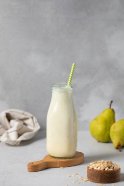 Sağlıklı kahvaltı için cam şişede armut ve yulaf püresi. Detoks ve diyet kavramı