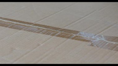  Mühürlü bir karton paketi açmak için maket bıçağı kullanan eller. İnternetten mal alırken kutu kesen bir adamın elleri. İnternetten alışveriş