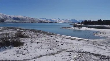 Nefes kesici ve resimli bir kış sahnesi güzel karla kaplı arazi ve sakin göl sularını gözler önüne seriyor.